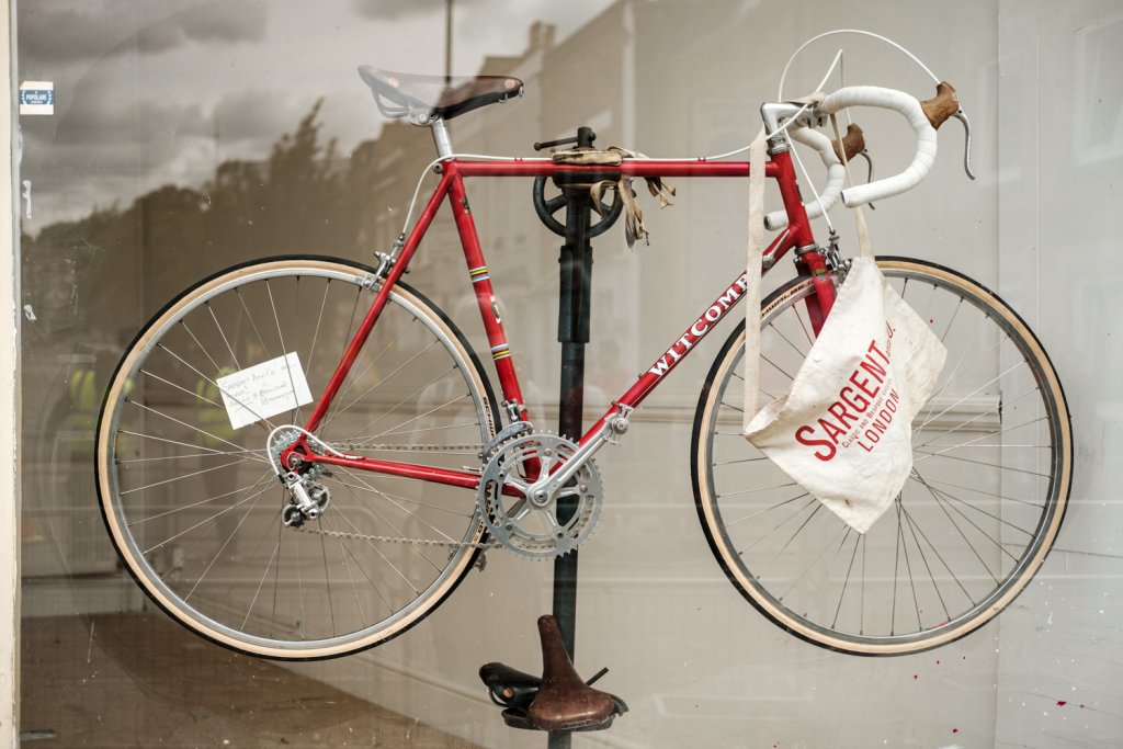 A red framed racing bicycle in a shop window.